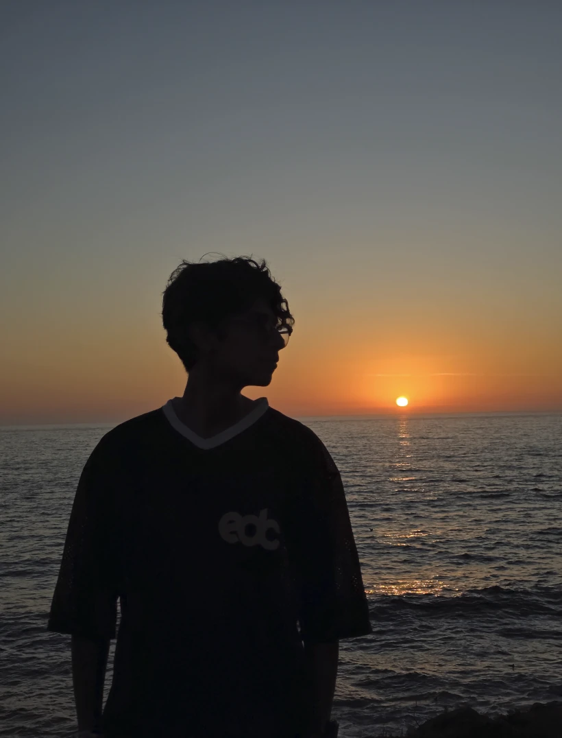 Kevin Molina Antonio en silueta frente al mar al atardecer